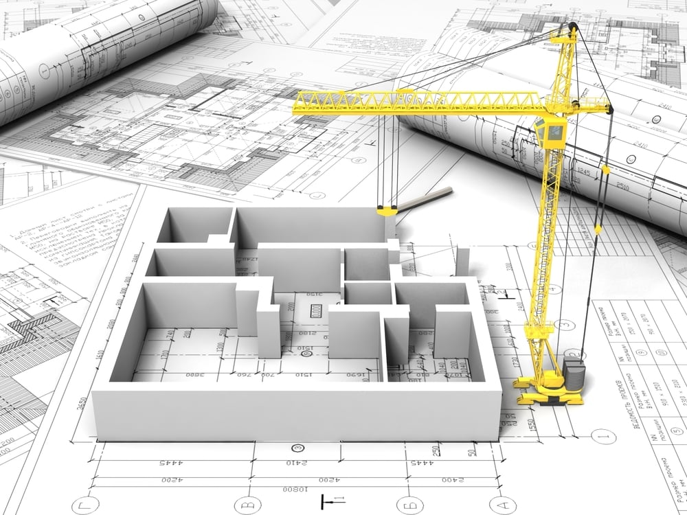 3D floor plan model on architectural blueprints with a yellow construction crane in the background